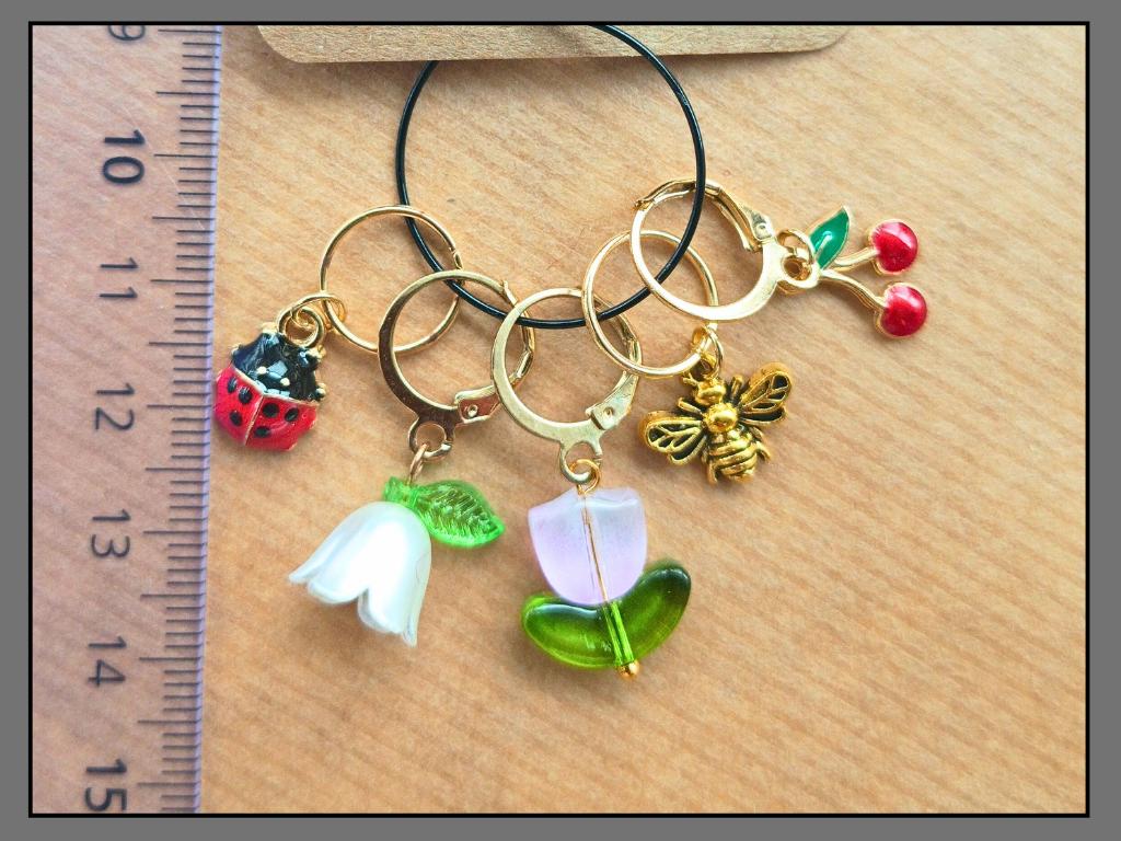 Stitch marker set with flower, cherry, ladybug and bee pendants for knitting and crochet projects. 