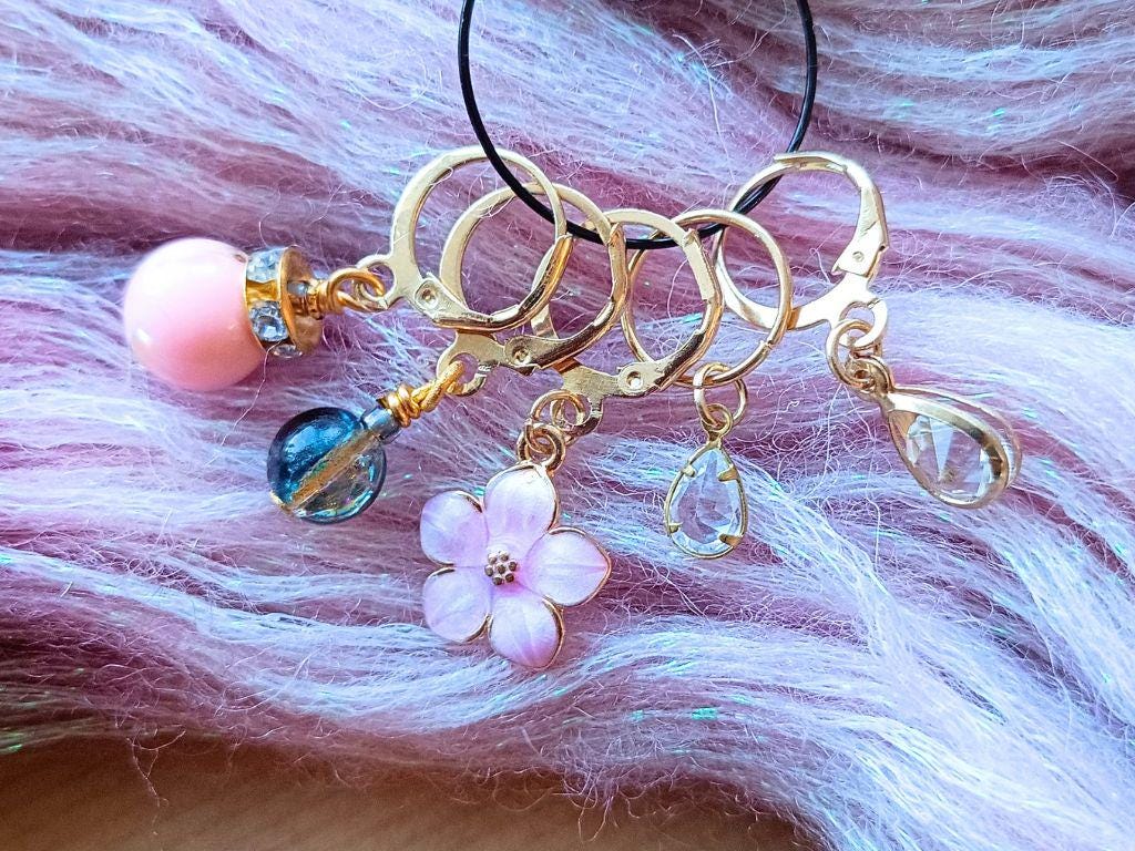 Stitch marker set with pendants and beads for knitting and crochet projects.
