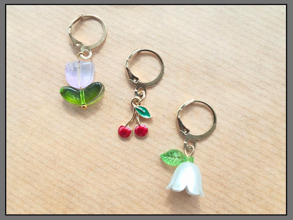 Stitch marker set with flower, cherry, ladybug and bee pendants for knitting and crochet projects. 