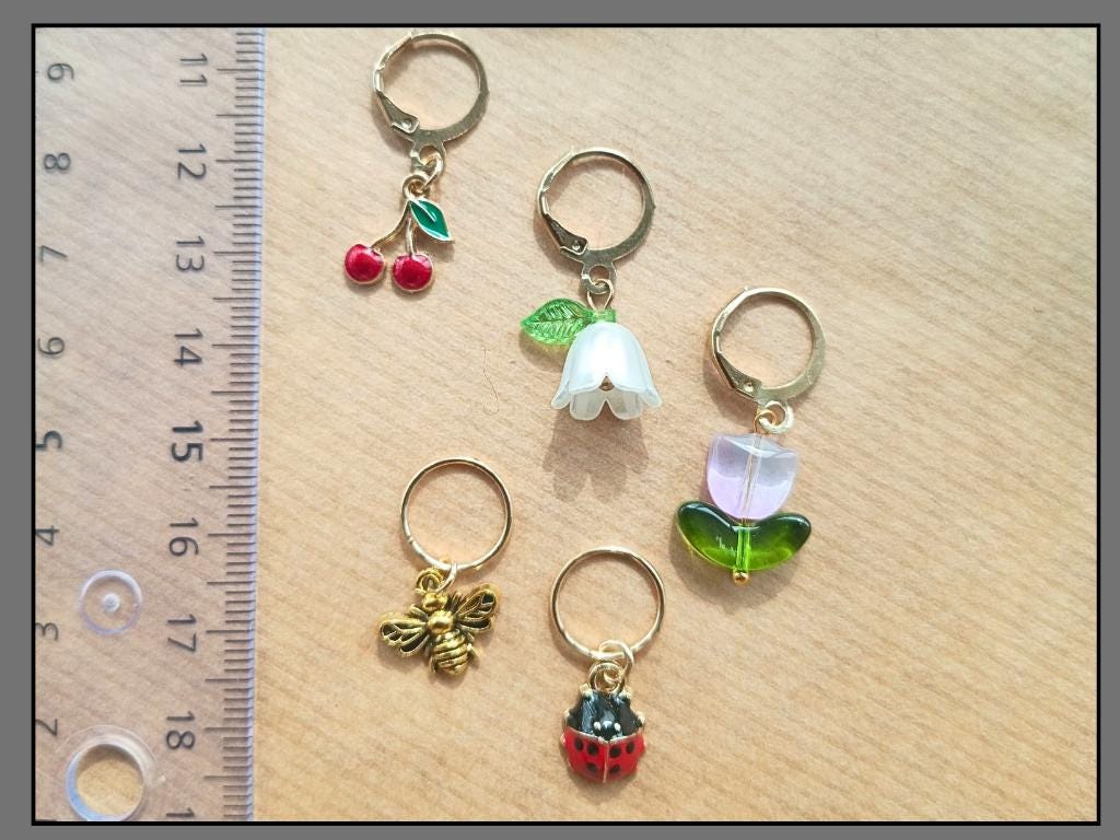 Stitch marker set with flower, cherry, ladybug and bee pendants for knitting and crochet projects. 