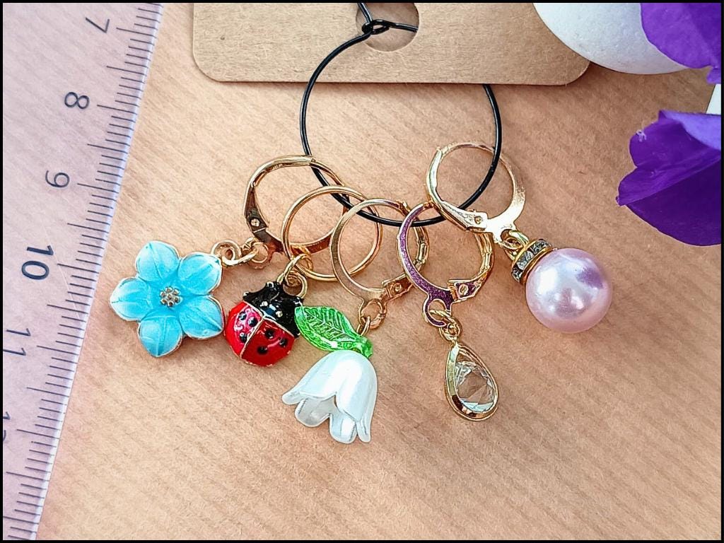 Stitch marker set with flowers, ladybug, pearl and drop pendant for knitting and crochet projects. 