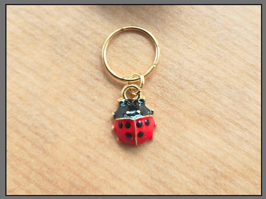 Stitch marker set with flower, cherry, ladybug and bee pendants for knitting and crochet projects. 