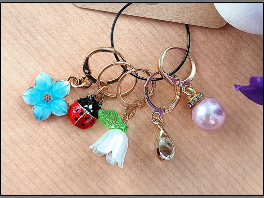 Stitch marker set with flowers, ladybug, pearl and drop pendant for knitting and crochet projects. 